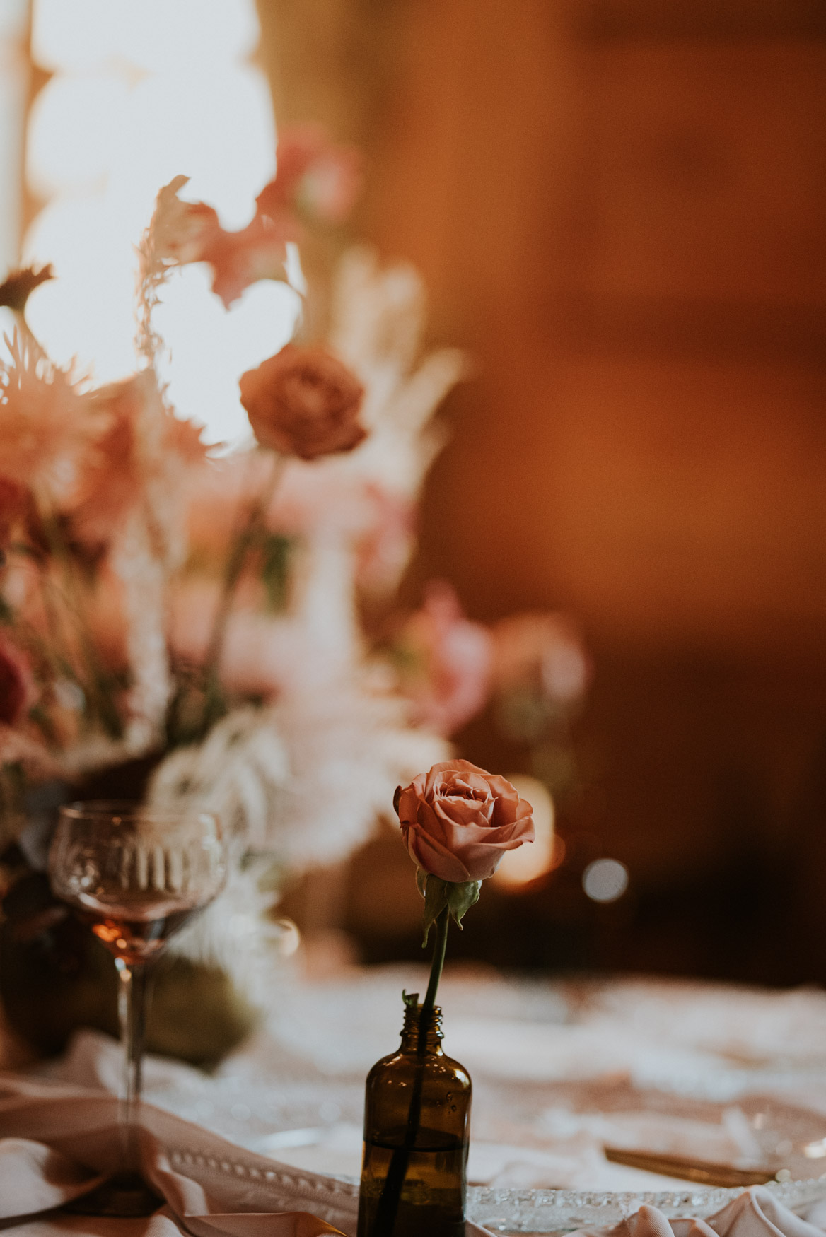 kwiat sfotografowany na małej głębi ostrości w otoczeniu traw i innych kwiatów